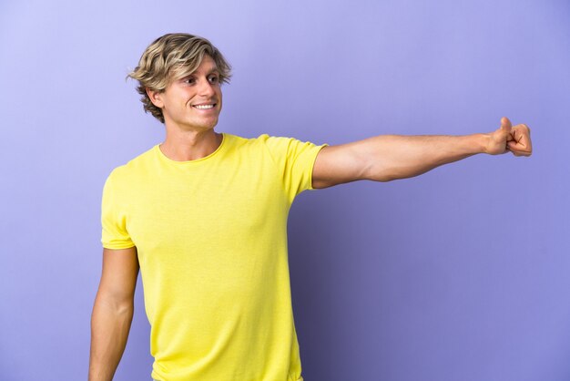 English man over isolated purple wall giving a thumbs up gesture