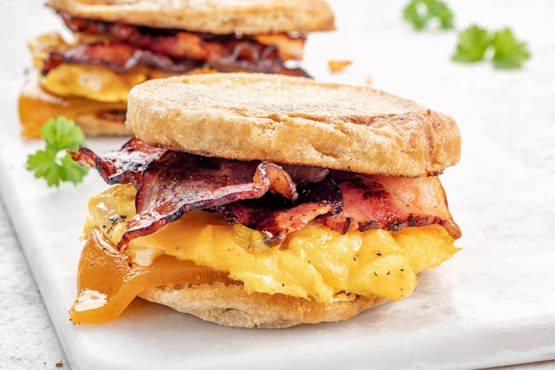 English muffin egg ham and cheese breakfast sandwich on a cutting board