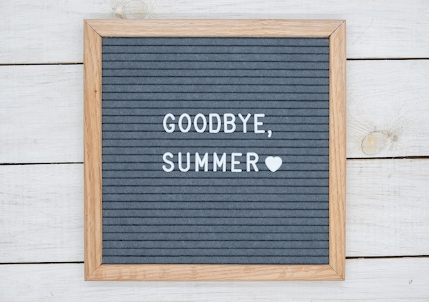 English text goodbye summer on a letter Board in white letters on a gray background and a symbol of heart.