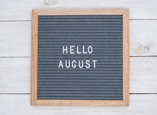 Photo english text hello august on a letter board in white letters