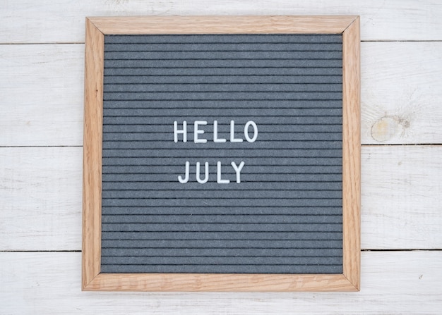 Photo english text hello july on a letter board in white letters