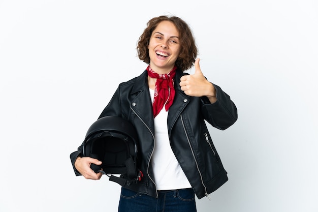 English woman holding a motorcycle helmet on white with thumbs up because something good has happened