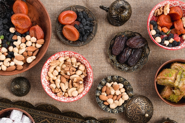 Engraved metallic; copper and ceramic bowl with dried fruits and nuts on jute tablecloth