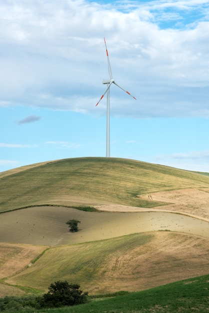 Enige windturbine in landbouwgrond op een heuveltop