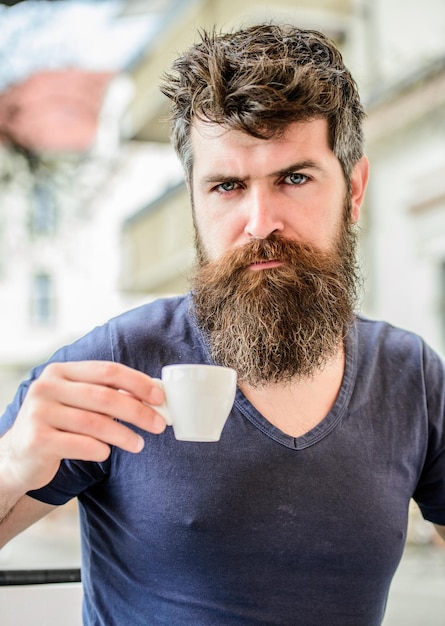 Enjoy hot drink Hipster drinking fresh brewed coffee Bearded guy consume caffeine Espresso arabica only Coffee break concept Guy relaxing espresso Man with beard and mustache and espresso cup