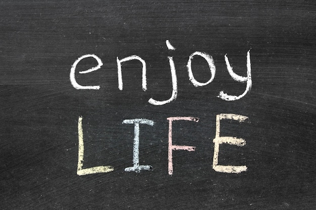 Photo enjoy life phrase handwritten on the school blackboard