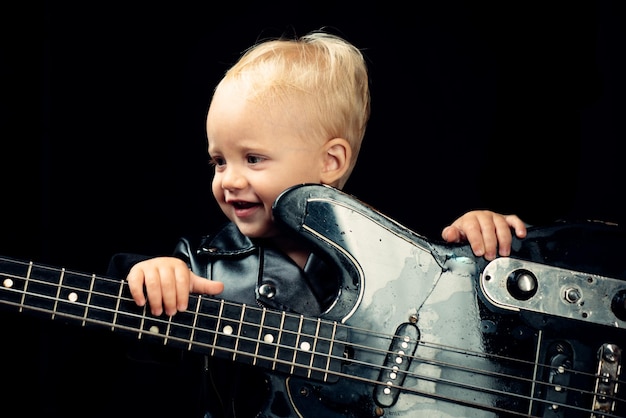 Enjoy live music little guitarist in rocker jacket little rock star child boy with guitar rock style