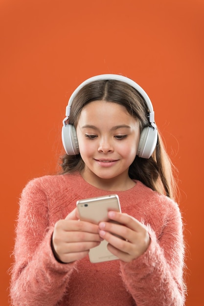 Enjoy perfect sound best music apps for free girl child listen music modern headphones and smartphone listen for free get music account subscription access to millions songs enjoy music concept