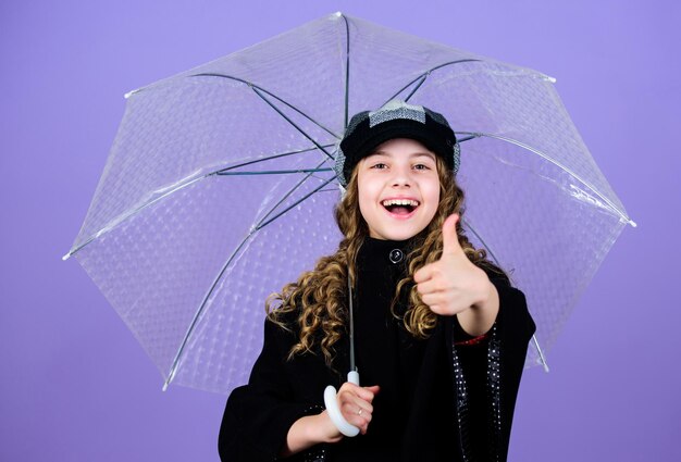 雨のコンセプトを楽しむ 秋のシーズン キッズファッショントレンド 雨の日が大好き 子供の女の子は透明な傘を持って幸せです 適切な衣服で雨天を楽しみます 防水アクセサリーは雨の日を楽しくします