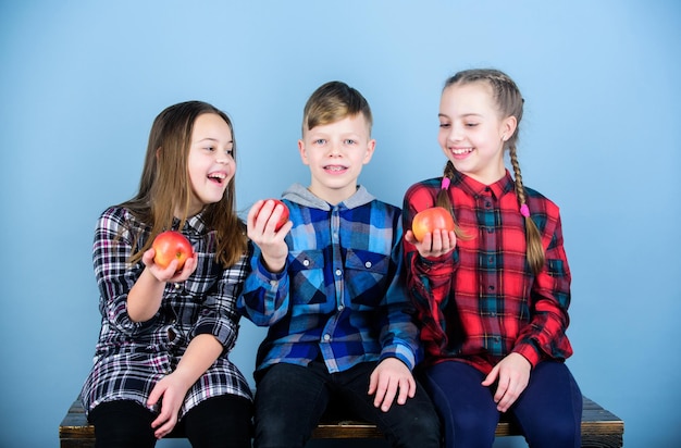 Enjoy the taste of eating right Healthy children Little children holding red apples Small group of children eating apples together Cute children with healthy apple snack