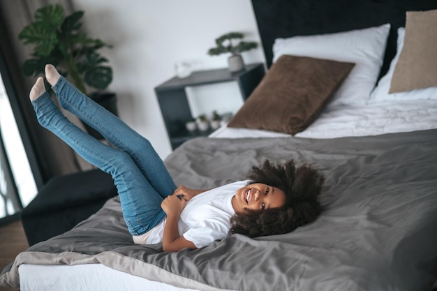 Foto mi è piaciuto. una ragazza carina dai capelli ricci che si diverte e sembra divertita