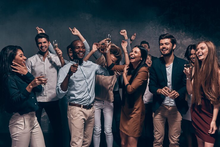 Photo enjoying amazing party. group of beautiful young people dancing with champagne flutes and looking happy