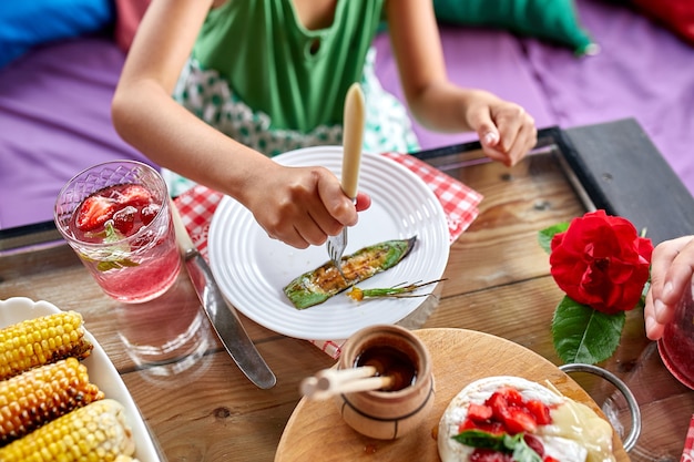 夕食を楽しむ子供女の子がナイフとフォークで食べる、夕食のテーブル、前菜のバラエティサービング