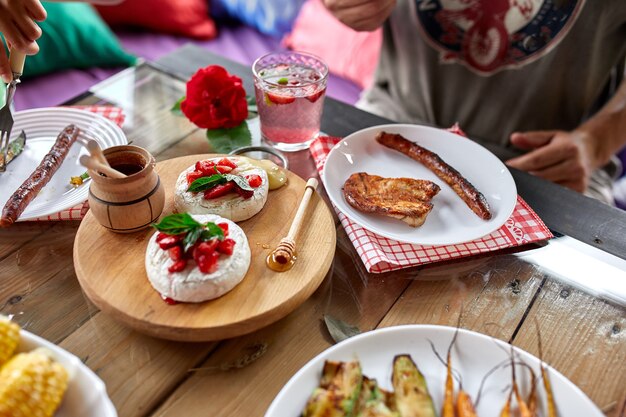 Наслаждаясь ужином, обеденным столом, разнообразными закусками, которые подают на стол на открытом воздухе у себя дома.