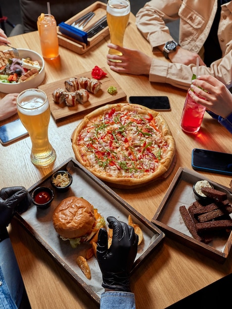 Photo enjoying dinner with friends top view of group of people having dinner together while sitting at the rustic wooden table