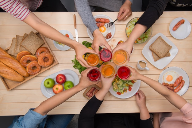 Enjoying dinner with friends.  Top view of group of people having dinner together while sitting at wooden table