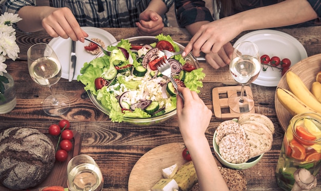 友達とディナーを楽しんでいます。一緒に夕食を食べている人々のグループのトップビュー