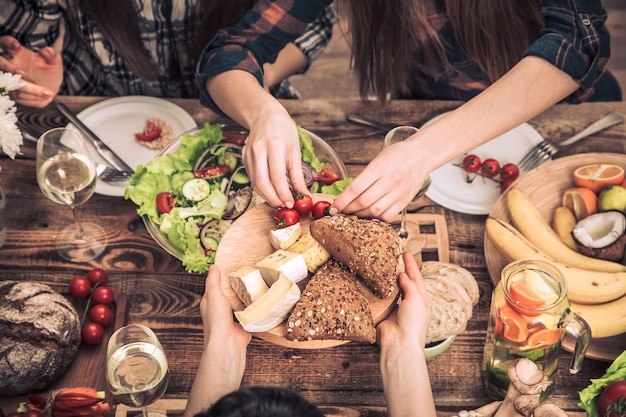 友達とディナーを楽しんでいます。一緒に夕食を食べている人々のグループのトップビュー