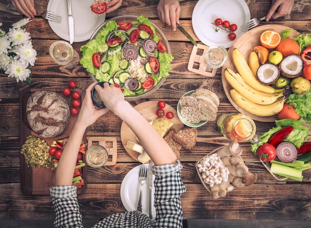 写真 友達とディナーを楽しんでいます。一緒に夕食を食べている人々のグループのトップビュー