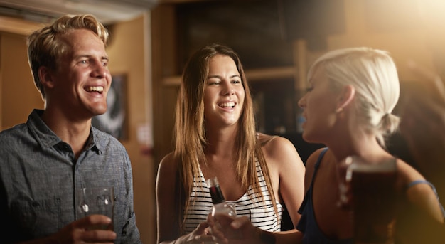 Godersi una serata divertente con gli amici scatto di un gruppo di amici che si divertono al bar