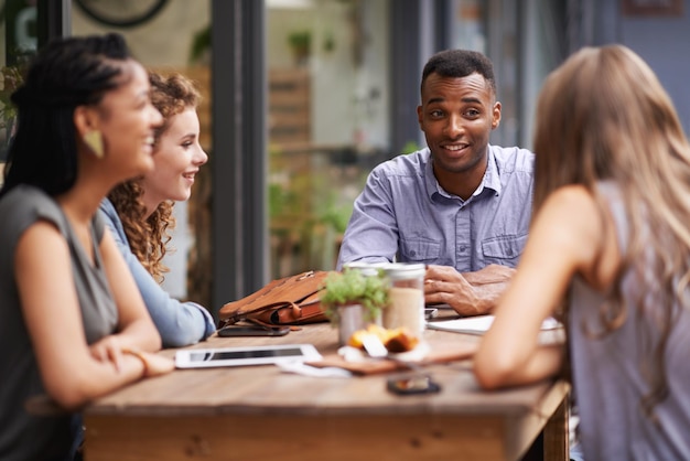 Enjoying good company and a great location A group of young friends sitting outside at a sidewalk cafe