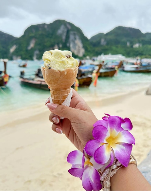 Enjoying the holidays a sweet moment by the sea Holding an ice cream cone Flower and shell bracelet