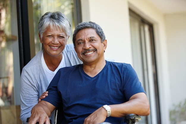 Photo enjoying a life enriched with love portrait of a senior woman pushing her husband in a wheelchair outdoors