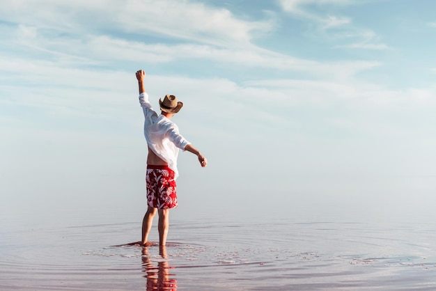 Enjoying majestic view Man in hat and casual clothes walks on lake at Jarilgach island Ukraine