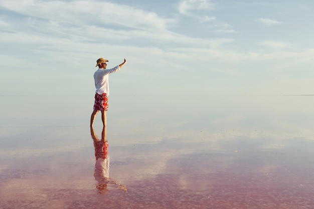 Enjoying majestic view Man in hat and casual clothes walks on lake at Jarilgach island Ukraine