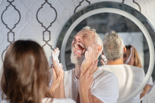 Enjoying the morning. Spouses having fun while playing with shaving foam