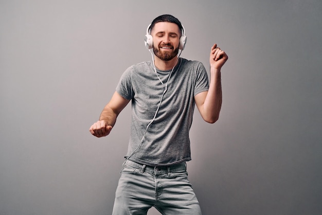 Enjoying the music Young handsome man is listening to music with his eyes closed and a dance