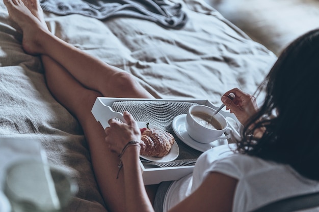 Photo enjoying nice breakfast. top view view of young woman having breakfast