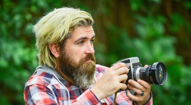 Enjoying summer journalist is my career reporter make photo vintage camera capture these memories SLR camera hipster man with beard use professional camera photographer hold retro camera