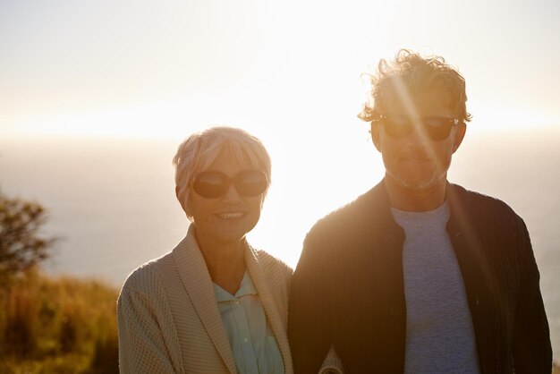 Enjoying a sunset Cropped view of a senior couple standing on a hillside together