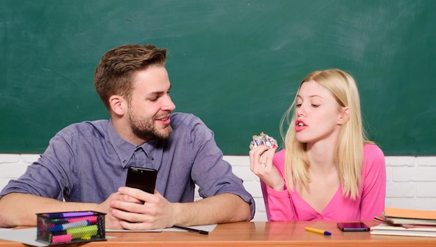 Enjoying time in college. Studying in college or university. Friends students studying university. College fun. Modern education. Having fun in college. Guy and girl carefree sit at desk in classroom.