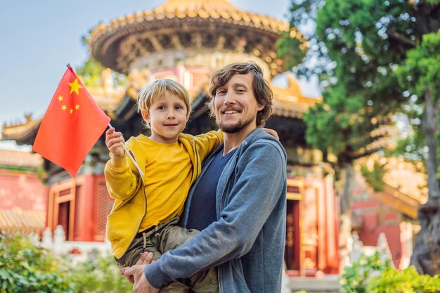 Enjoying vacation in China Happy family with national chinese flag in Forbidden City Travel to China with kids concept Visa free transit 72 hours 144 hours in China