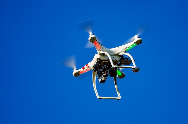 Enkele drone quadrocopter die in de blauwe lucht vliegt