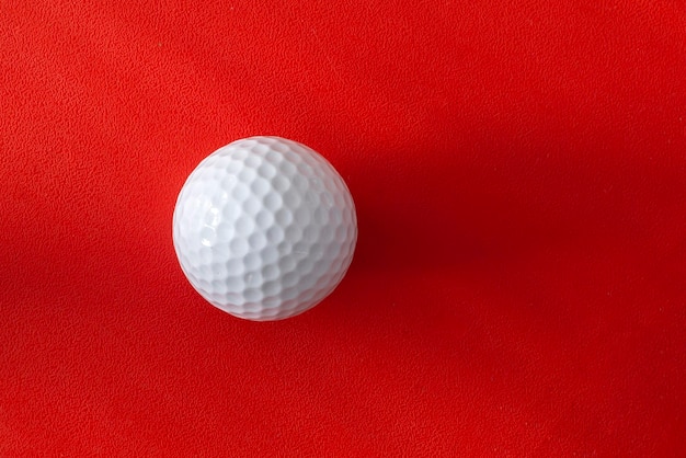 Enkele golfbal op een rode achtergrond