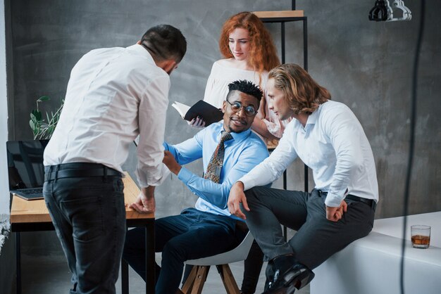 Enkele ideeën delen. Groep multiraciale kantoormedewerkers in formele kleding praten over taken en plannen