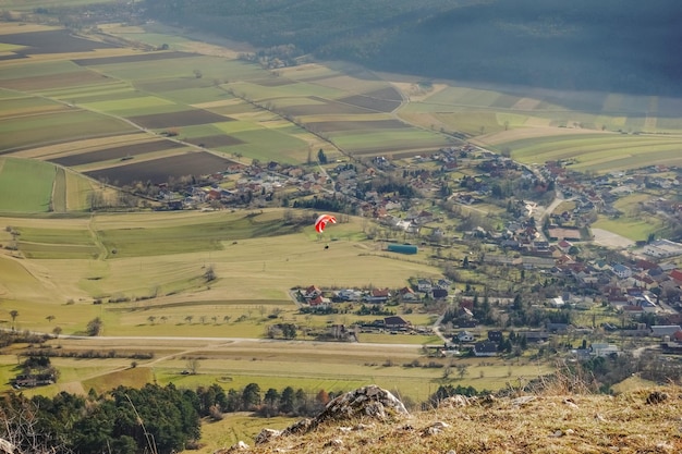 Enkele kleurrijke paraglider op een berg in een groene vallei