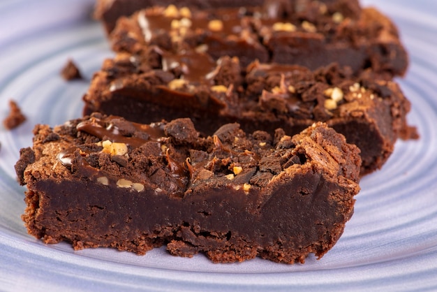 Enkele plakjes brownie op een blauw bord.