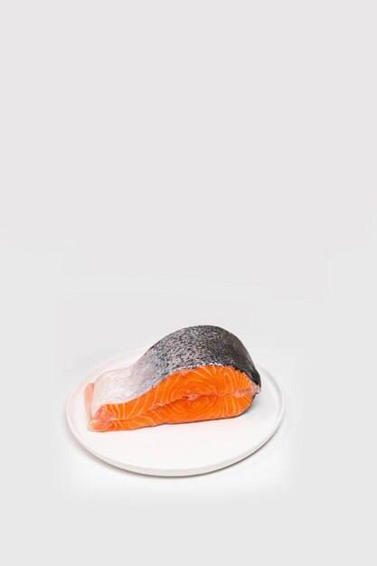 Enkele verse rauwe zalm vis steak op witte achtergrond. creatieve minimalistische lay-out gemaakt van vis met kopieerruimte