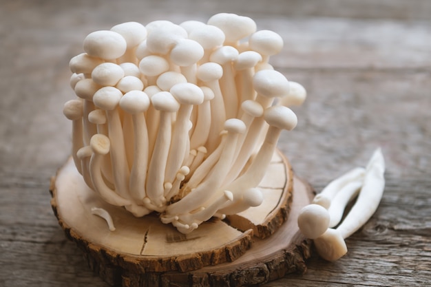 Enoki mushrooms on wooden table, close up.