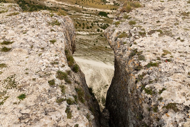 Enorme grijze rotsen met een spleet en uitzicht op de canyon Uitzicht van bovenaf selectieve focus