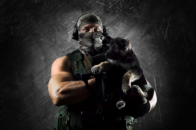 Enorme militaire man houdt een kleine puppy in zijn armen. Gemengde media