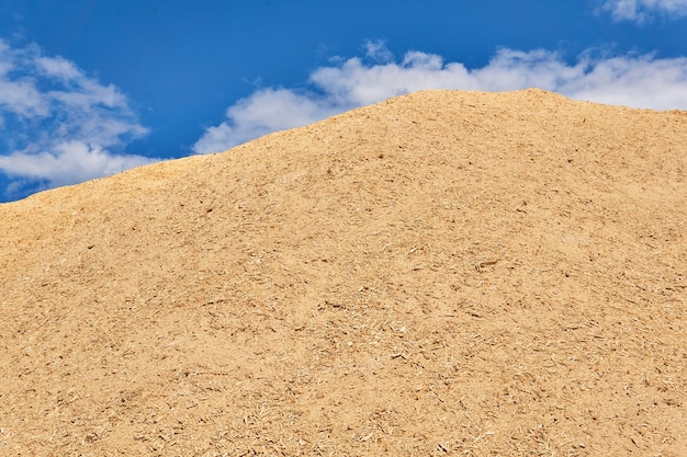 Enorme stapel vers houtzaagsel tegen de lucht