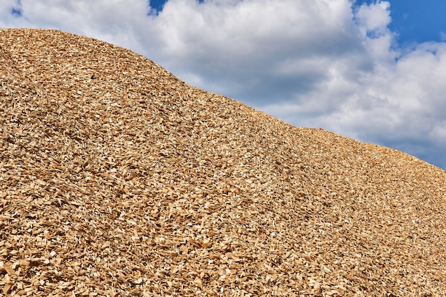 Enorme stapel verse houtsnippers tegen de lucht