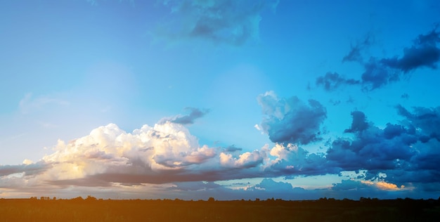 Enorme wolken aan de avondlucht met zonnestralen