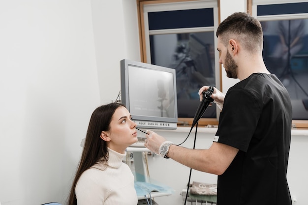 ENT doctor using fibrolaryngoscope to examine and treat the ears ENT specialist diagnoses and treats larynx and pharynx such as hoarseness vocal cord nodules tumors infections and inflammation