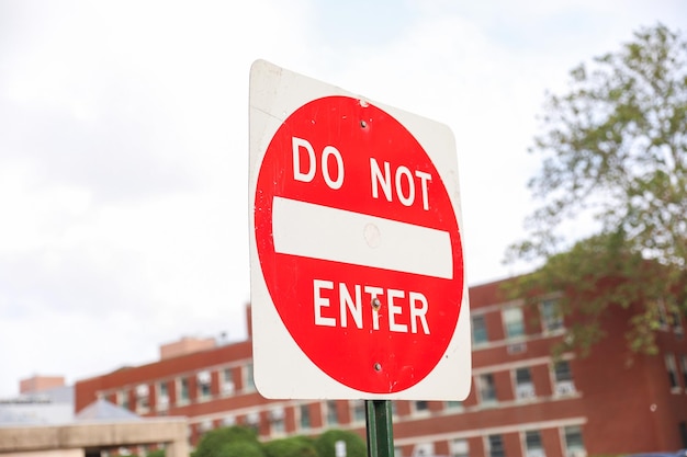 A do not enter sign is on a green pole.